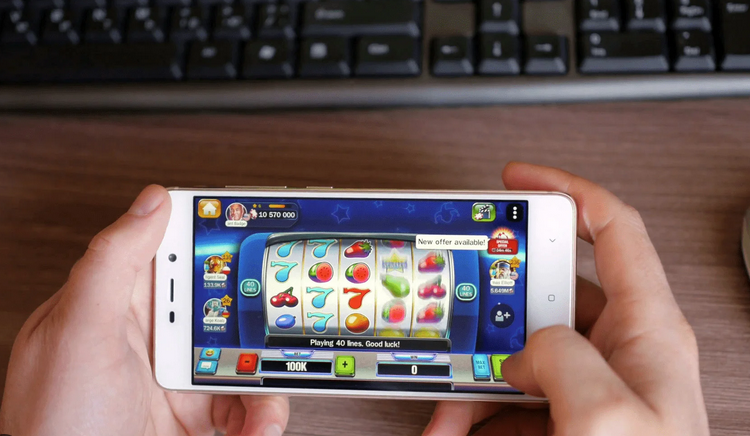 a person holding a white phone playing slot games